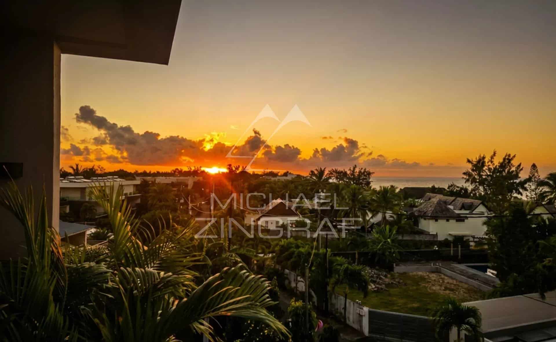 Sunset from a penthouse in Pointe aux Canonniers Sunset view from a penthouse in Pointe aux Canonniers, with palm trees in the foreground.