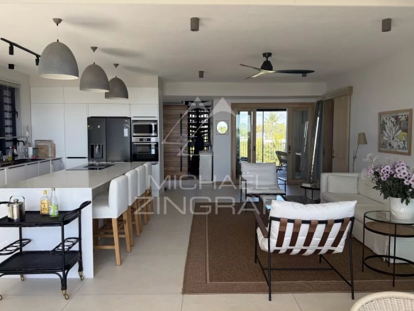 Interior of a modern penthouse with open kitchen and living room, sea view.