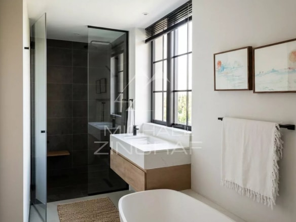 Modern bathroom with glass shower and bathtub in a penthouse in Pointe aux Canonniers.
