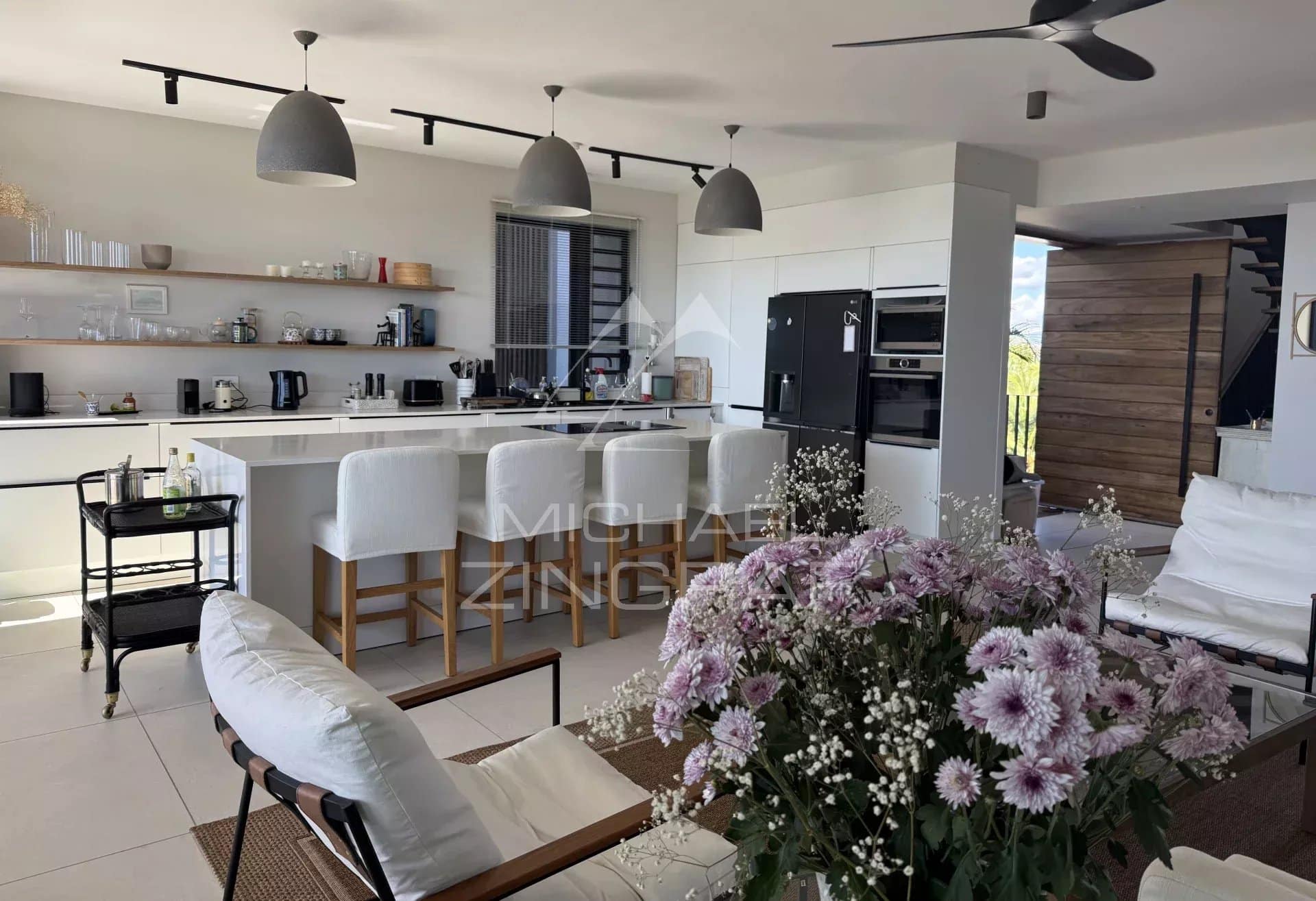 Modern penthouse in Pointe aux Canonniers Interior of a modern penthouse with open kitchen and living room, decorated with flowers.
