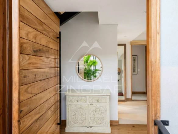 Entrance to a penthouse with modern decor and wooden furniture.