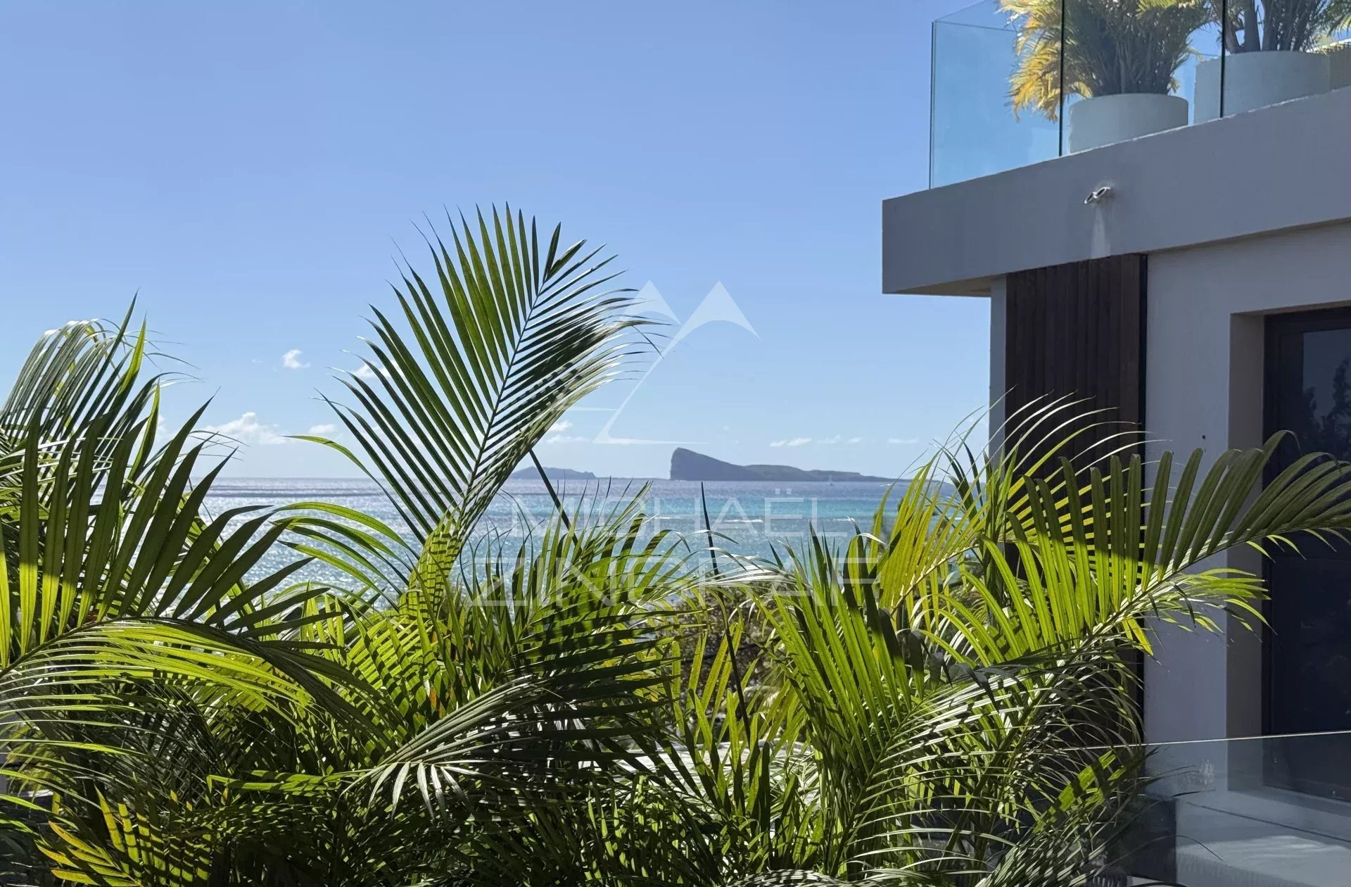 Penthouse with sea view in Pointe aux Canonniers View from a penthouse with palm trees and the sea in the background at Pointe aux Canonniers.