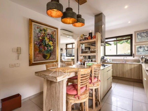Modern and bright kitchen of a villa in Mont Mascal, Grand Baie, with wooden furniture and pendant lights.