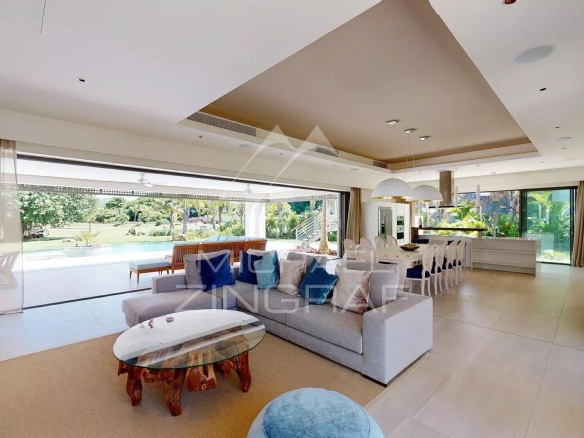 Interior of a modern villa with a spacious living room and bay windows overlooking the garden.