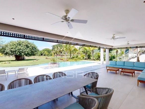 Spacious terrace of a modern villa with outdoor furniture and garden view.