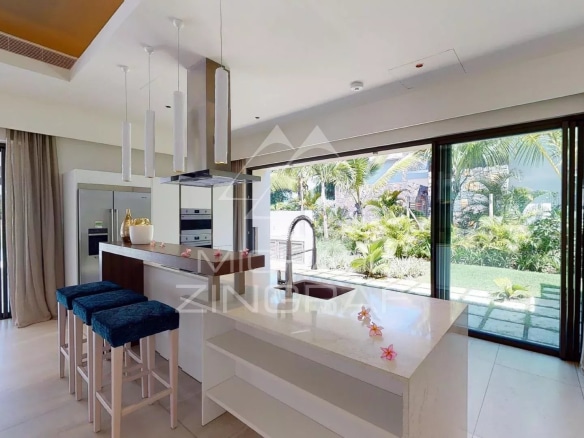 Modern kitchen with central island and bay windows overlooking the garden in a villa in Beau Champ, Mauritius.