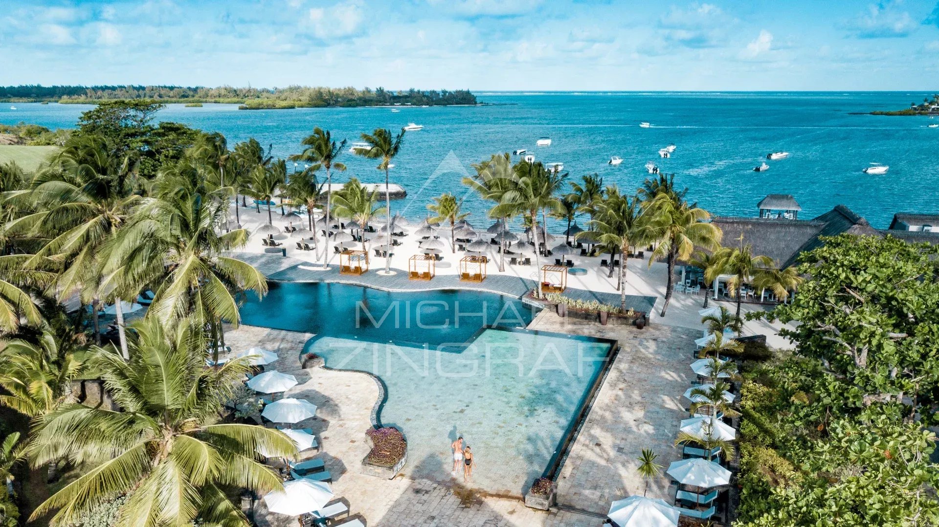 Modern villa in Mauritius Aerial view of a modern villa with pool and beach in Mauritius, surrounded by palm trees.