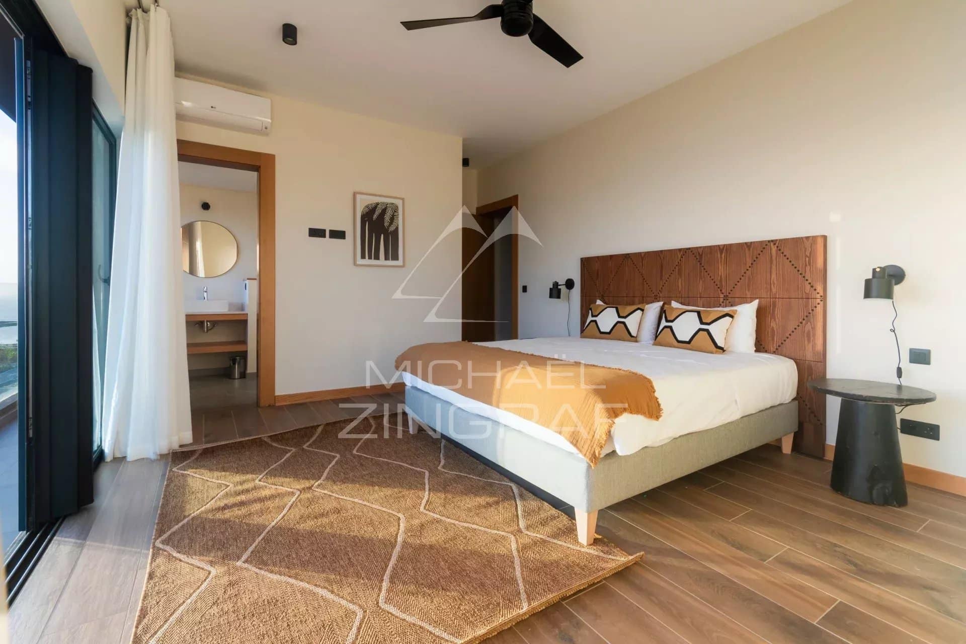 Chambre d'une villa avec lit double, décoration moderne et vue sur l'extérieur.