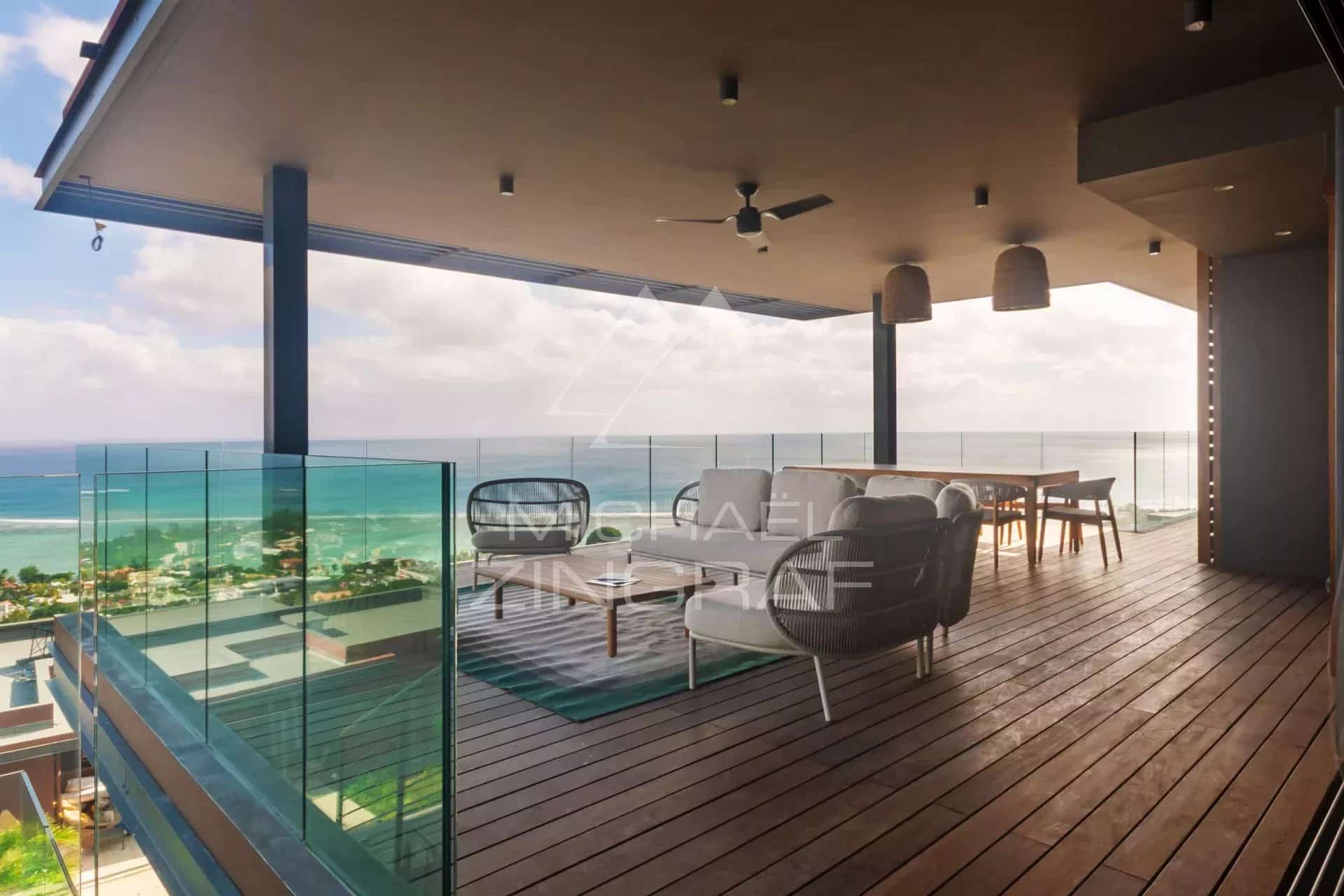 Terrasse avec vue sur la mer et mobilier moderne dans une villa à Rivière Noire.