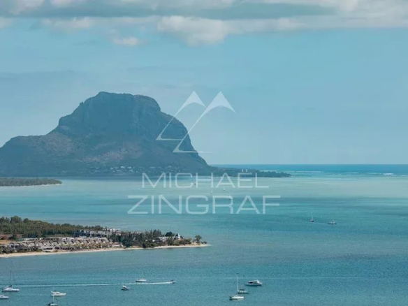 Vue panoramique de la mer et de la montagne à Rivière Noire, avec des bateaux au loin.