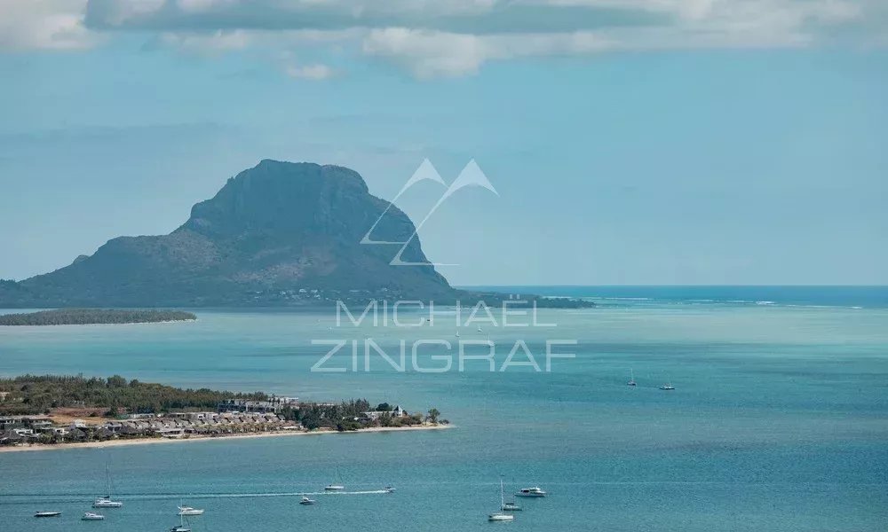 Vue panoramique de la mer et de la montagne à Rivière Noire, avec des bateaux au loin.