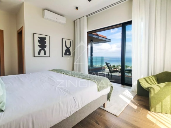 Chambre d'une villa moderne avec vue sur la mer à Rivière Noire, décorée avec des œuvres d'art.