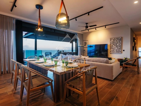 Intérieur d'une villa moderne avec salle à manger et vue sur la mer.