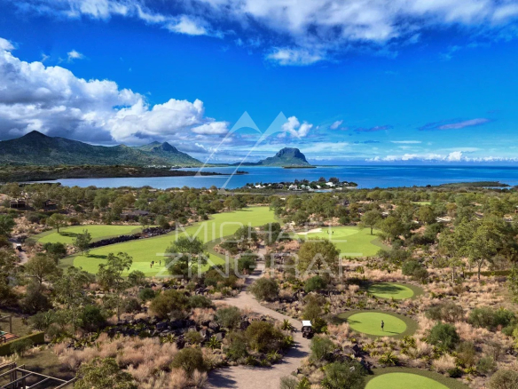 Vue aérienne d'une villa sur un golf à Rivière Noire, Île Maurice, avec montagnes et océan en arrière-plan.