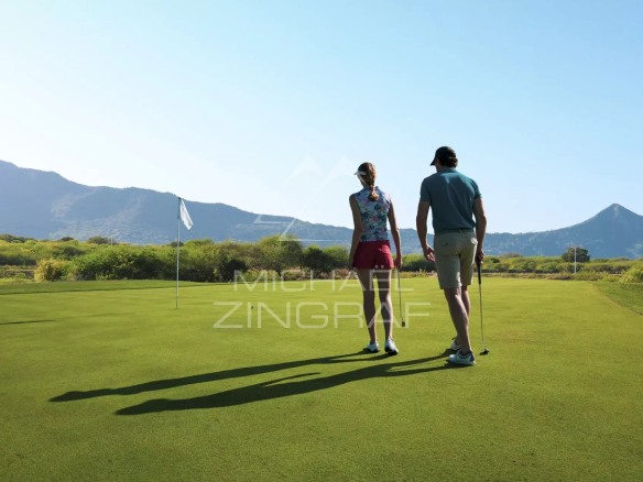 Deux personnes sur un green de golf avec des montagnes en arrière-plan à Rivière Noire, Île Maurice.