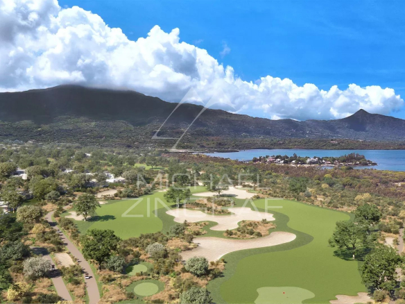 Aerial view of a villa on a golf course in Rivière Noire, Mauritius, with mountains in the background.