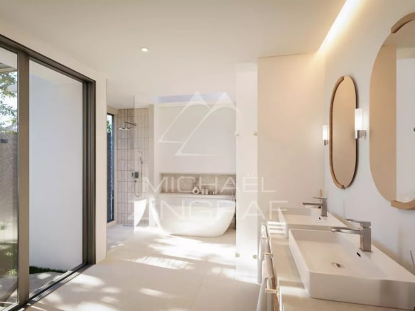 Salle de bain moderne avec baignoire et double vasque, lumière naturelle à Rivière Noire, Île Maurice.