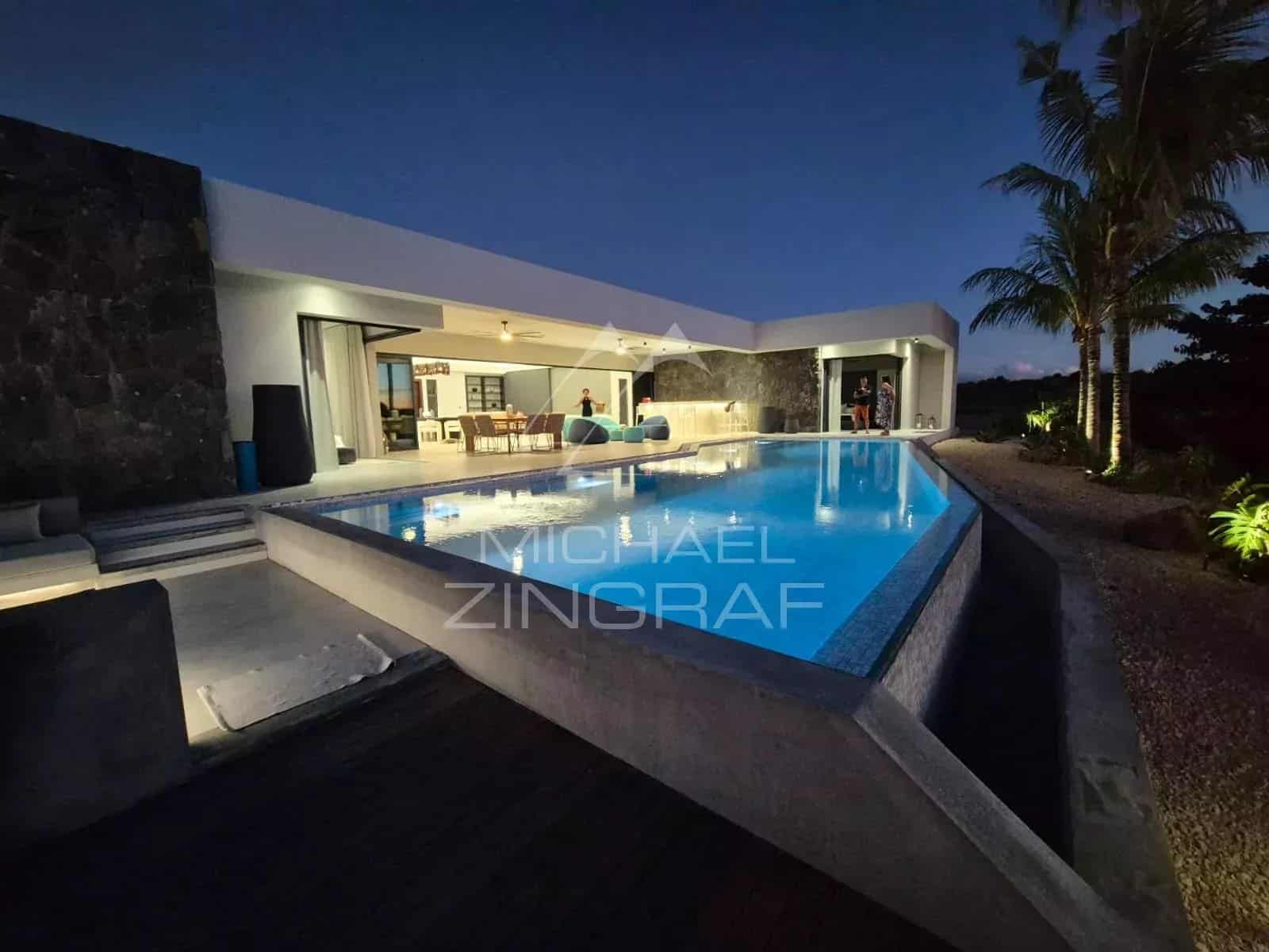 Contemporary villa with swimming pool in Mon Choisy Golf, Grand Baie, at night.