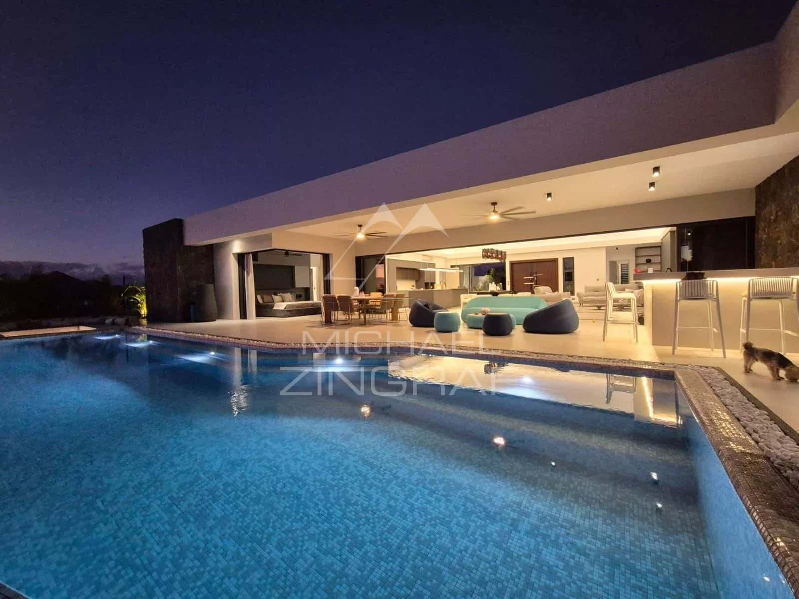 Contemporary villa with swimming pool in Mon Choisy Golf, Grand Baie, at night.