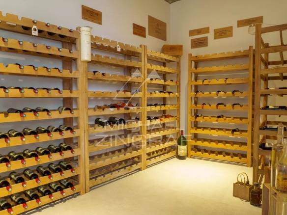 Cave à vin en bois avec étagères remplies de bouteilles.