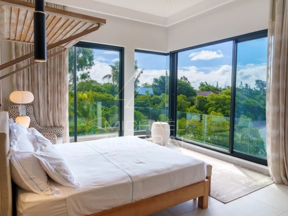 Chambre lumineuse avec vue sur le jardin dans une villa de luxe à Haute Rive.