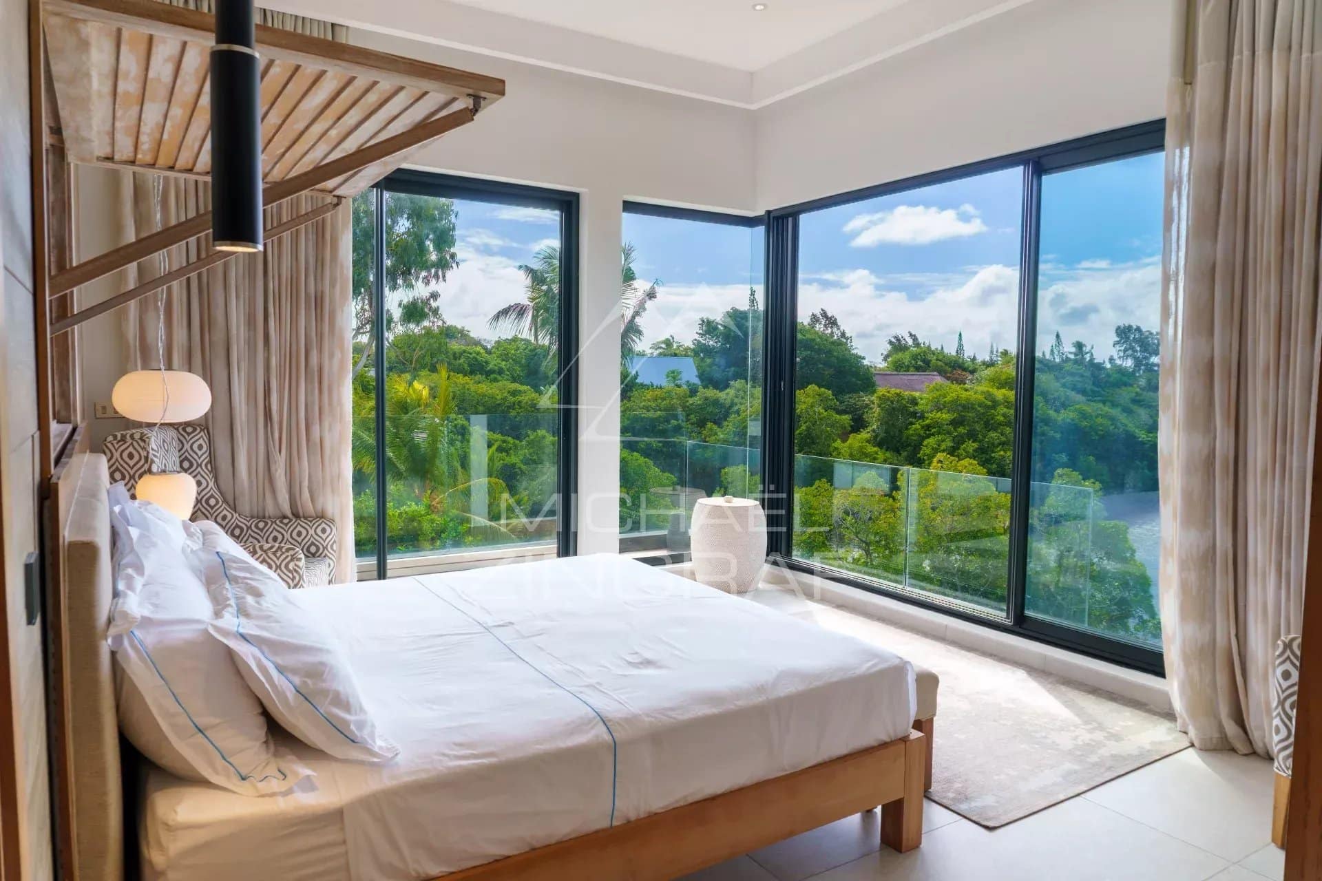 Chambre lumineuse avec vue sur le jardin dans une villa de luxe à Haute Rive.