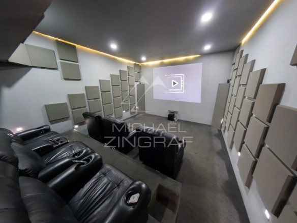 Salle de cinéma privée avec fauteuils en cuir et écran de projection