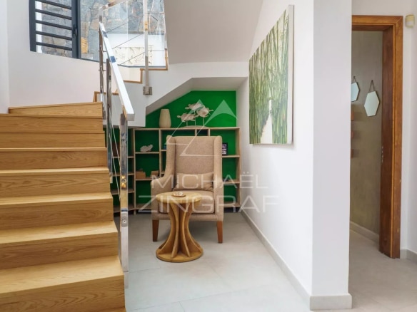 Intérieur d'une villa avec un escalier en bois et une décoration moderne.