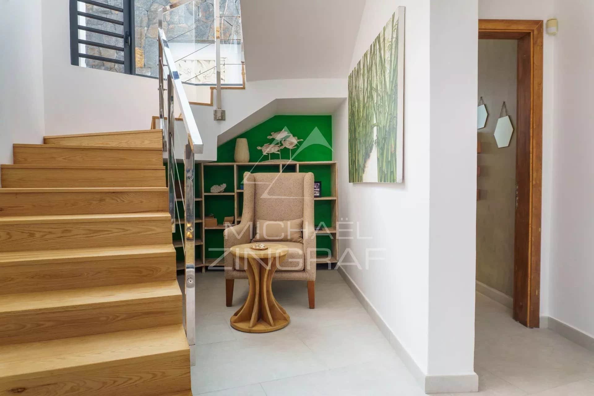Intérieur d'une villa avec un escalier en bois et une décoration moderne.