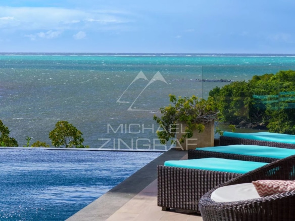 Vue sur la mer depuis une villa avec piscine à débordement et chaises longues.