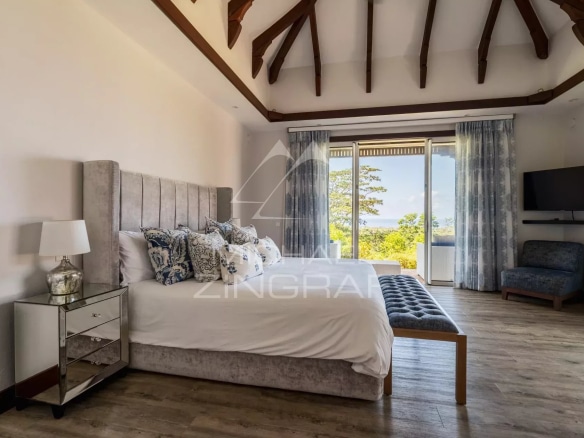 Chambre spacieuse avec lit king-size et vue sur l'extérieur dans une villa à Bel Ombre.