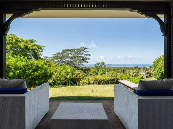 Terrasse d'une villa avec vue sur l'océan à Bel Ombre, entourée de verdure.