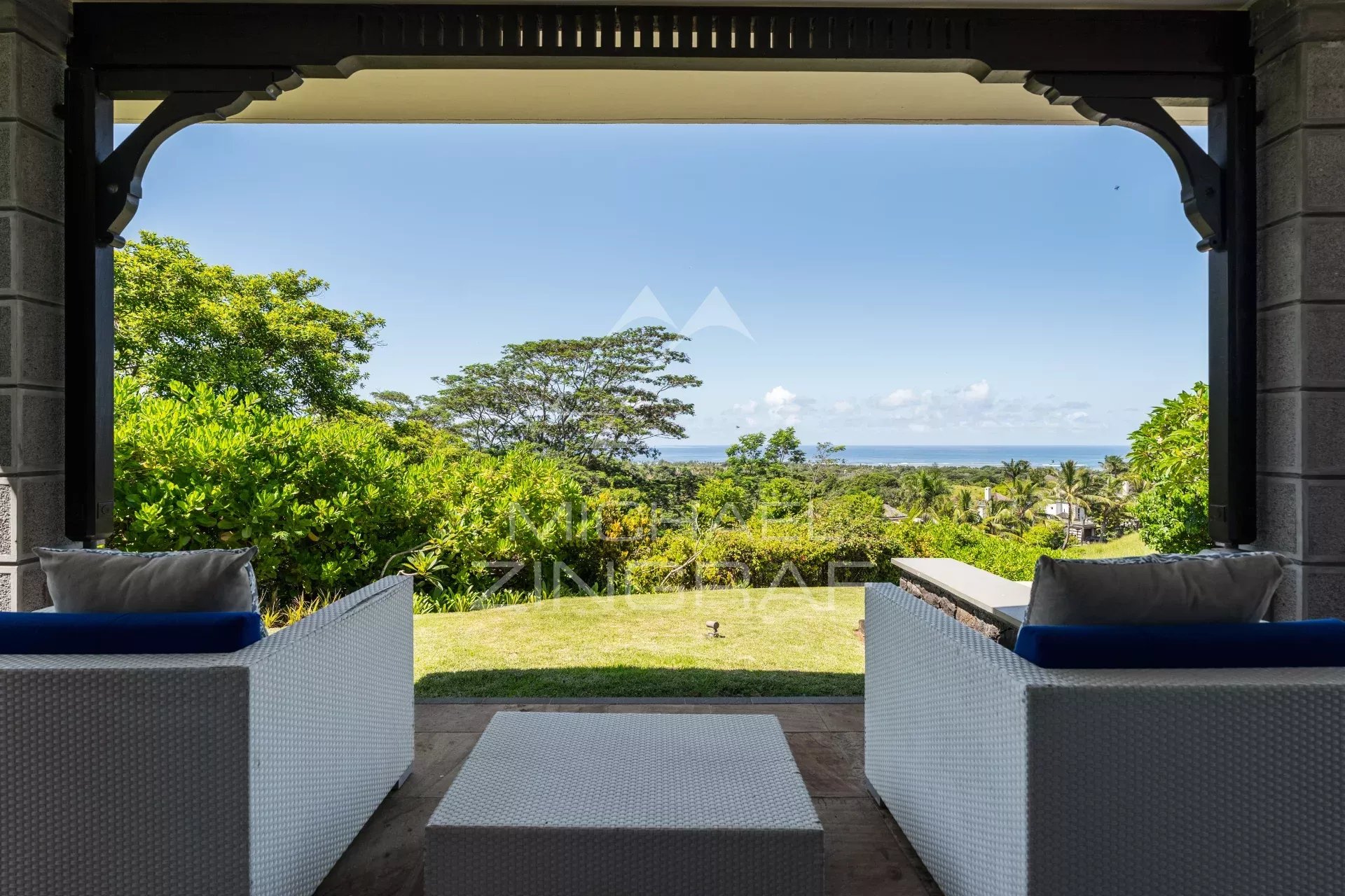 Villa avec vue panoramique sur l’océan Terrasse d'une villa avec vue sur l'océan à Bel Ombre, entourée de verdure.