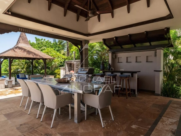 Terrasse extérieure d'une villa avec barbecue et espace repas, vue sur l'océan à Bel Ombre.