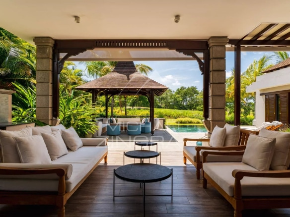 Terrasse d'une villa contemporaine avec salon extérieur et vue sur un parcours de golf à Bel Ombre.
