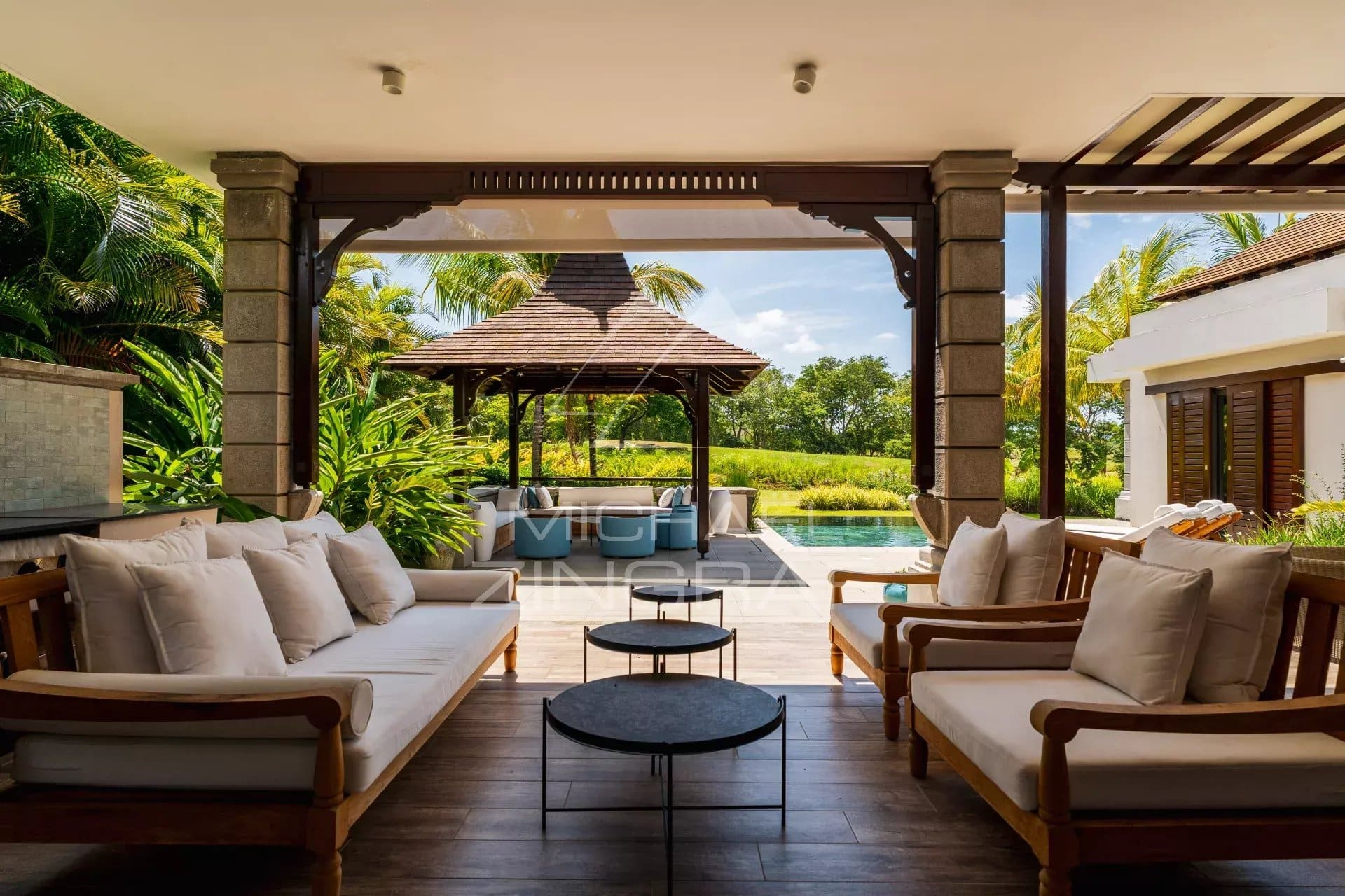 Terrasse d'une villa contemporaine avec salon extérieur et vue sur un parcours de golf à Bel Ombre.