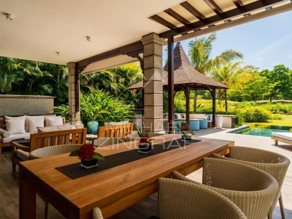 Terrasse d'une villa contemporaine avec mobilier en bois et vue sur un jardin verdoyant.