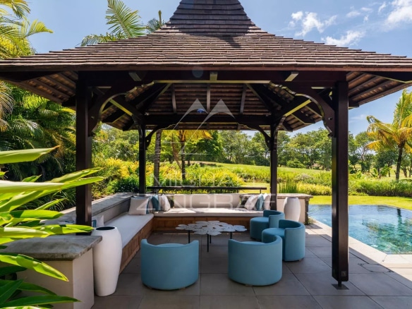 Terrasse d'une villa contemporaine avec mobilier moderne et vue sur un parcours de golf à Bel Ombre.