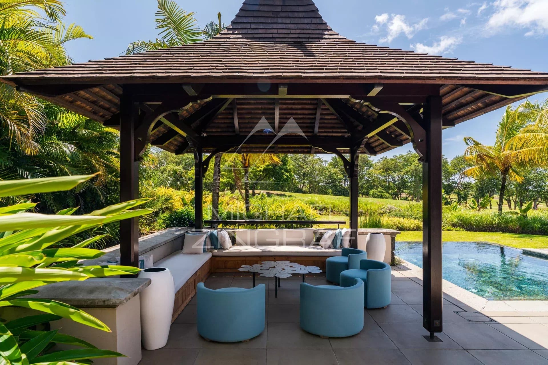 Terrasse d'une villa contemporaine avec mobilier moderne et vue sur un parcours de golf à Bel Ombre.