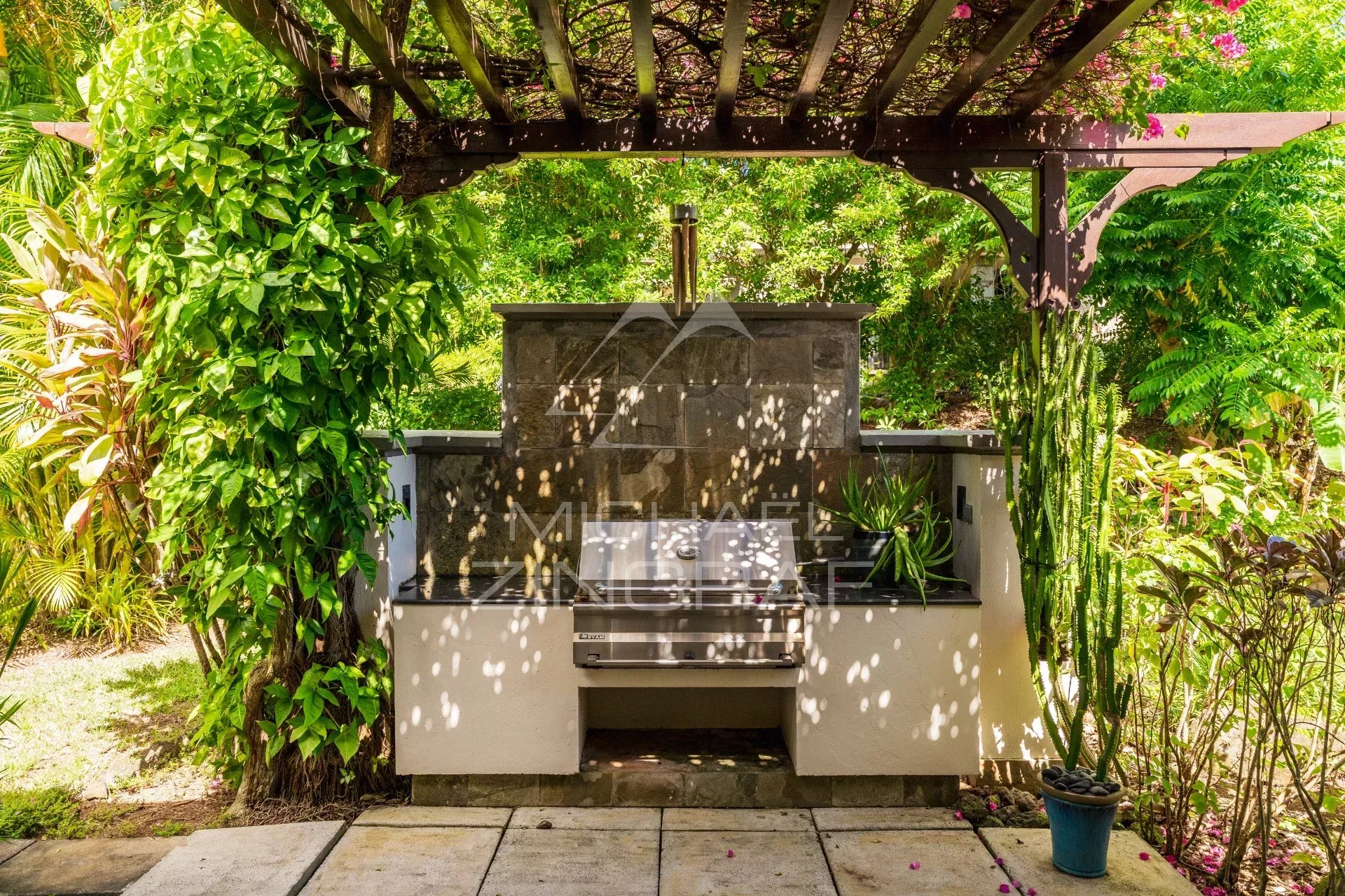 Outdoor barbecue area in a villa in Bel Ombre, Mauritius, surrounded by greenery.