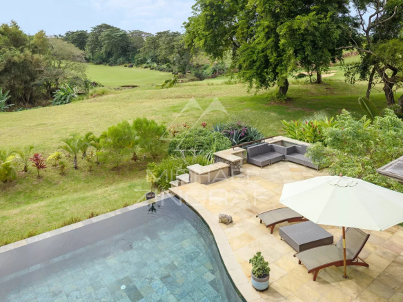 View of a villa with swimming pool and outdoor furniture on a golf course in Bel Ombre, Mauritius.
