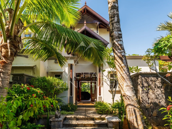 Entrance to a villa surrounded by palm trees and greenery in Bel Ombre, Mauritius.