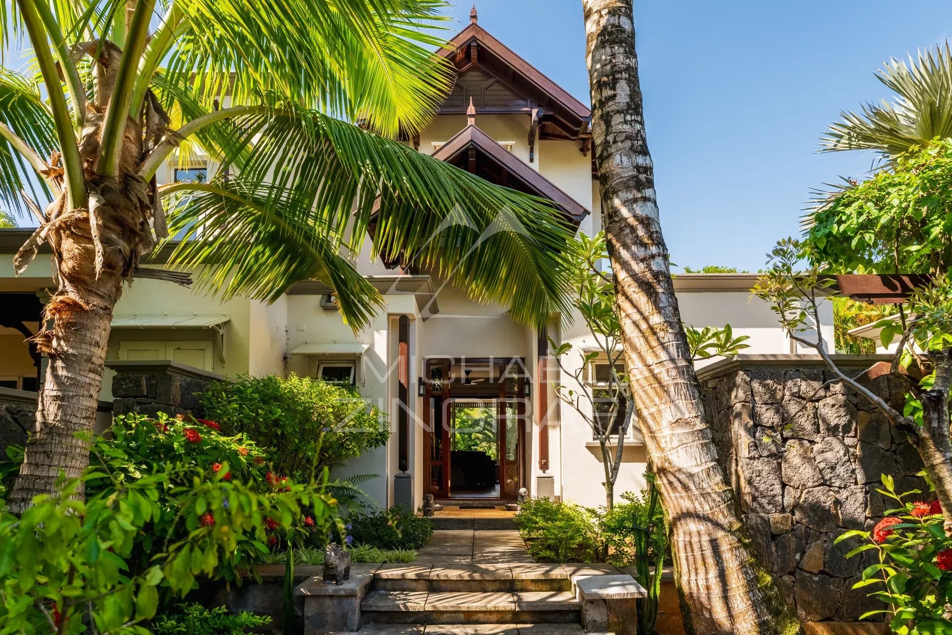 Entrance to a villa surrounded by palm trees and greenery in Bel Ombre, Mauritius.