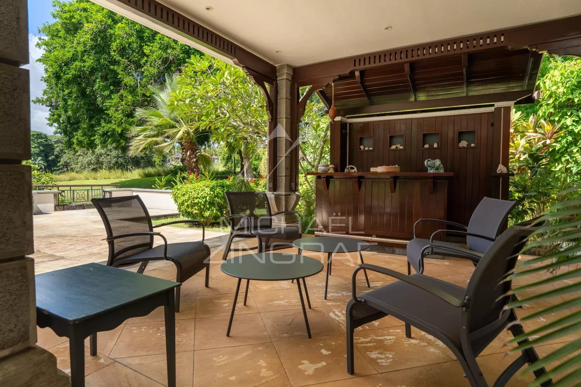 Terrace of a villa on a golf course in Bel Ombre, Mauritius, with garden furniture.