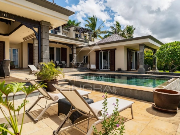 Modern villa with swimming pool and sun loungers, overlooking the garden in Bel Ombre, Mauritius.