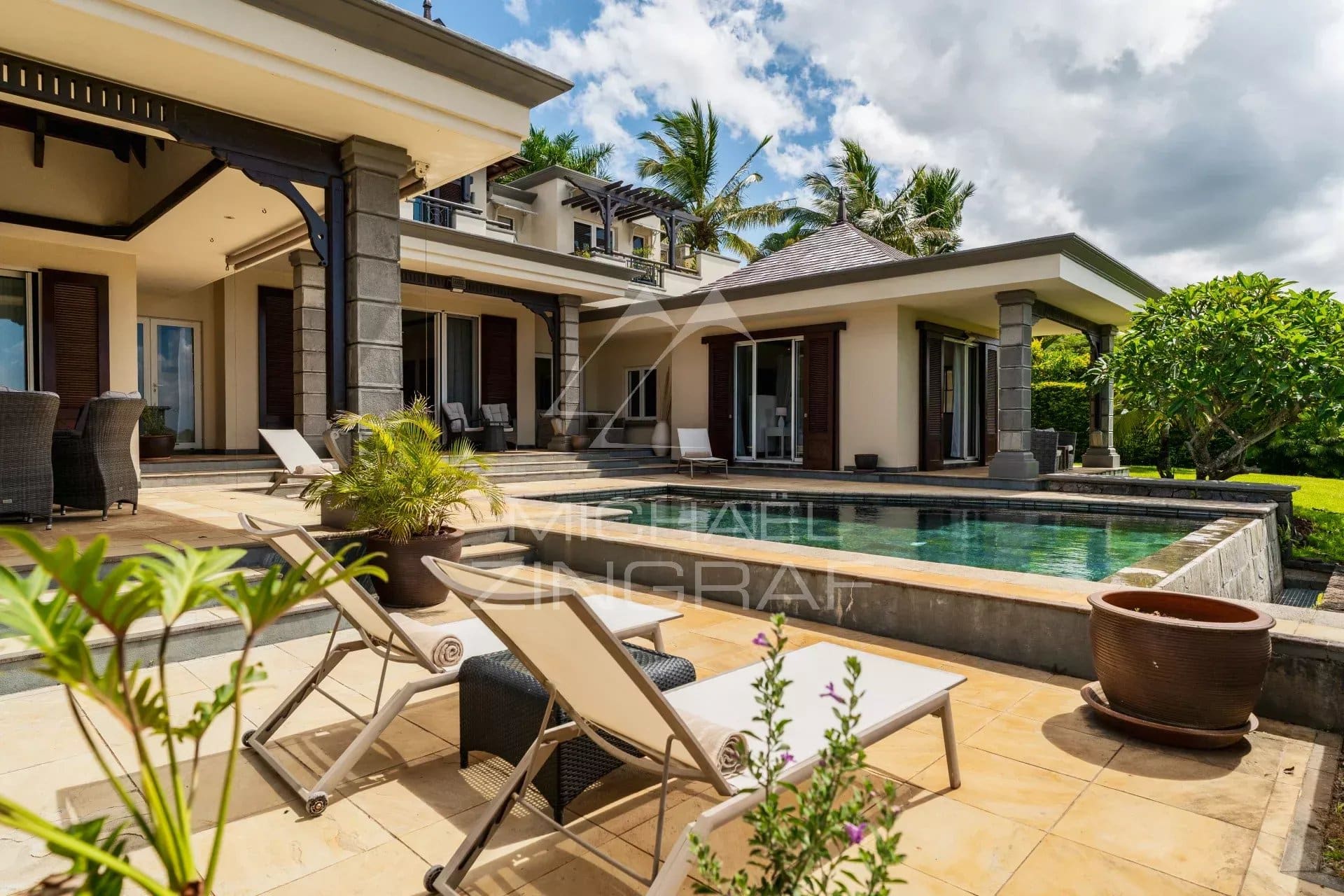 Modern villa with swimming pool and sun loungers, overlooking the garden in Bel Ombre, Mauritius.
