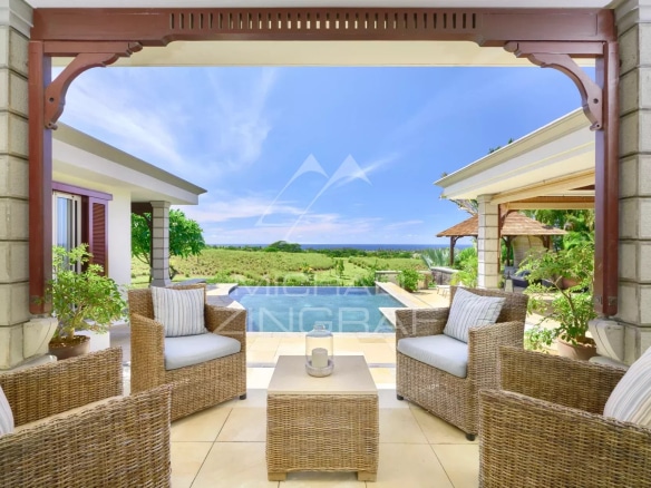 View from a villa terrace in Bel Ombre, with wicker furniture and the ocean in the background.
