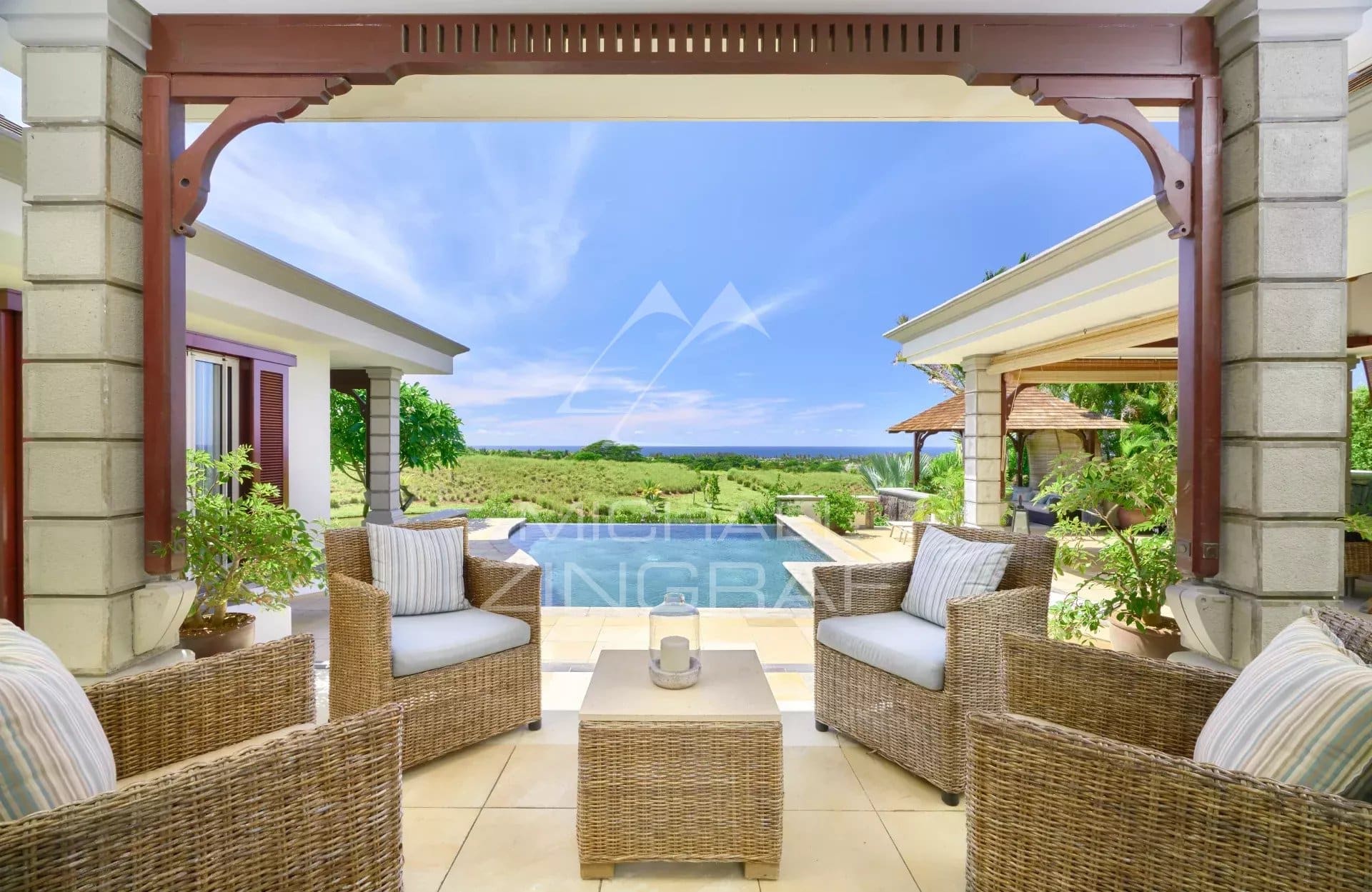 View from a villa terrace in Bel Ombre, with wicker furniture and the ocean in the background.