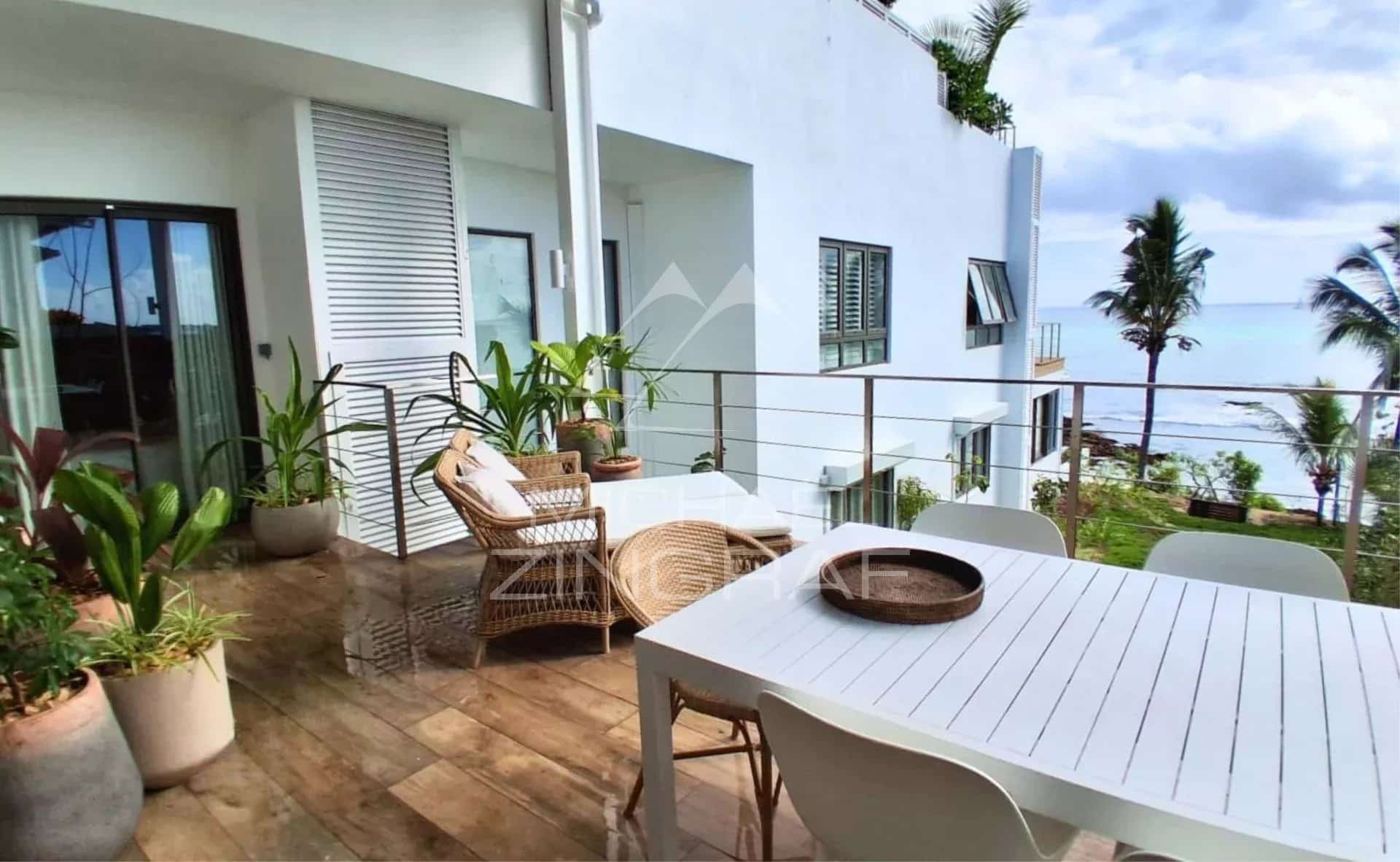 Terrace of an apartment in Pointe aux Canonniers with ocean view and decorative plants.
