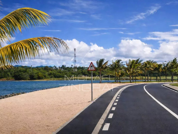 Route côtière avec palmiers et vue sur l'eau à Belle Mare, île Maurice.